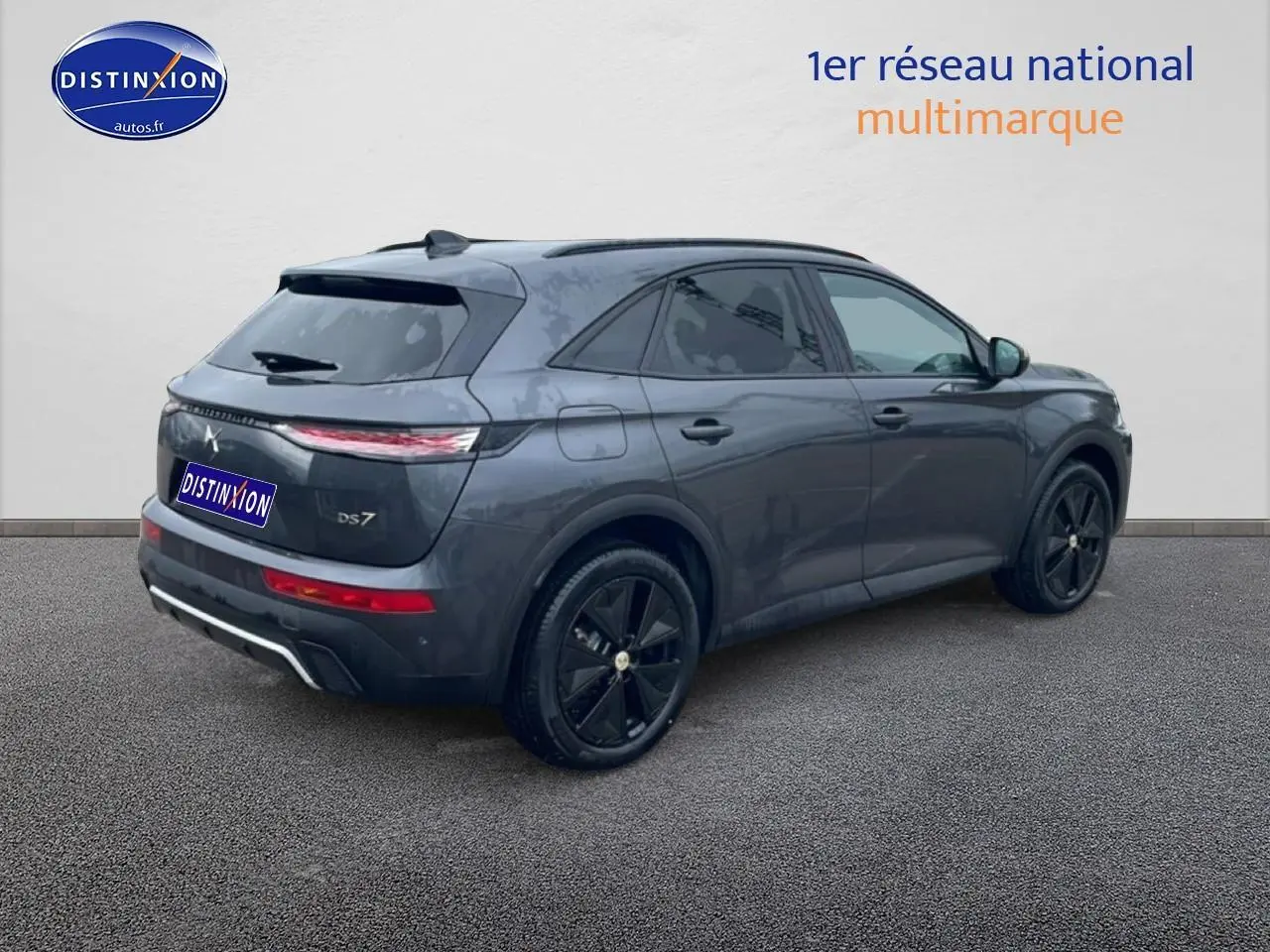 Vue 3/4 arrière droite du SUV DS7 gris titane avec jantes noires et feux arrière LED allongés.