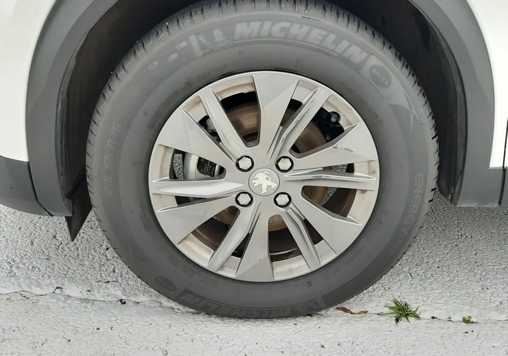 Gros plan sur la roue avant gauche blanche d'un Peugeot 2008 avec jante alliage et pneu Michelin Energy.