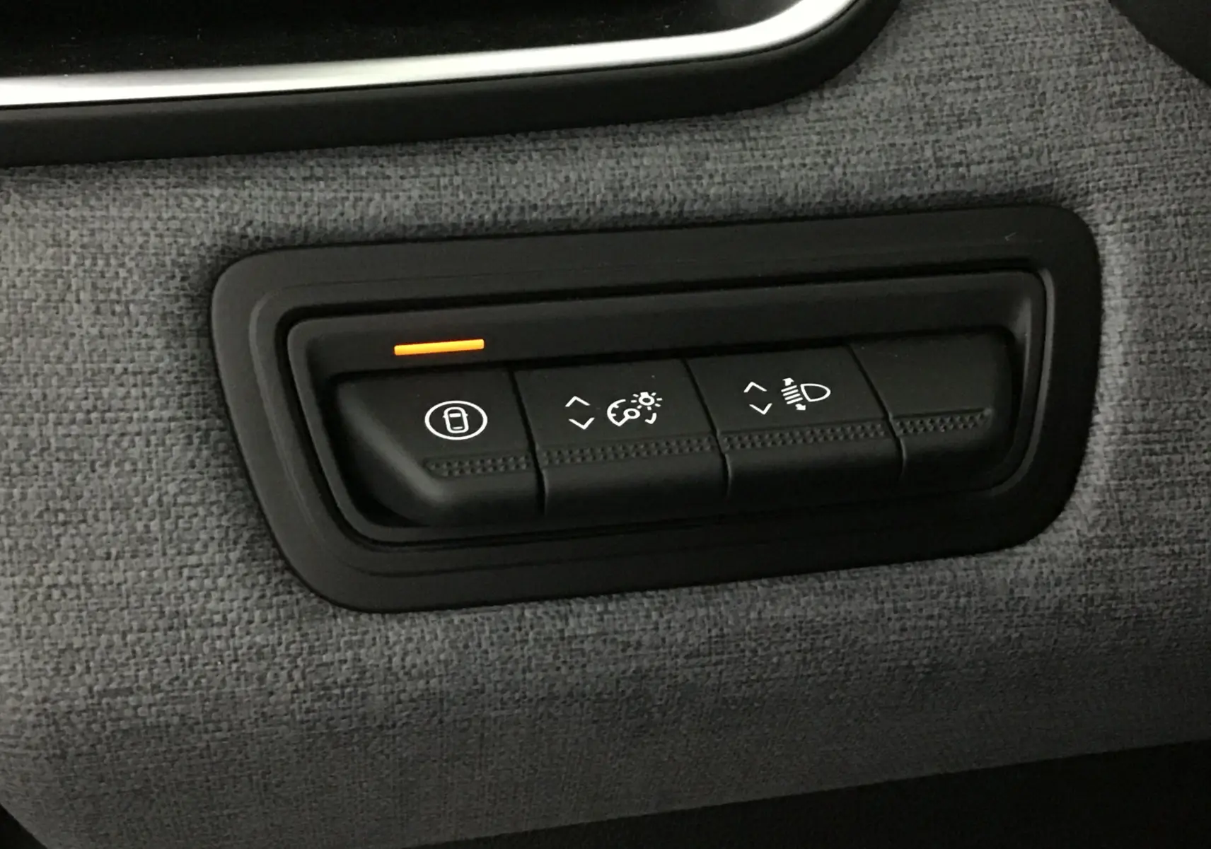 Gros plan sur les commandes d'éclairage et verrouillage de porte dans l'habitacle gris tissu d'une Renault Clio V 2025.