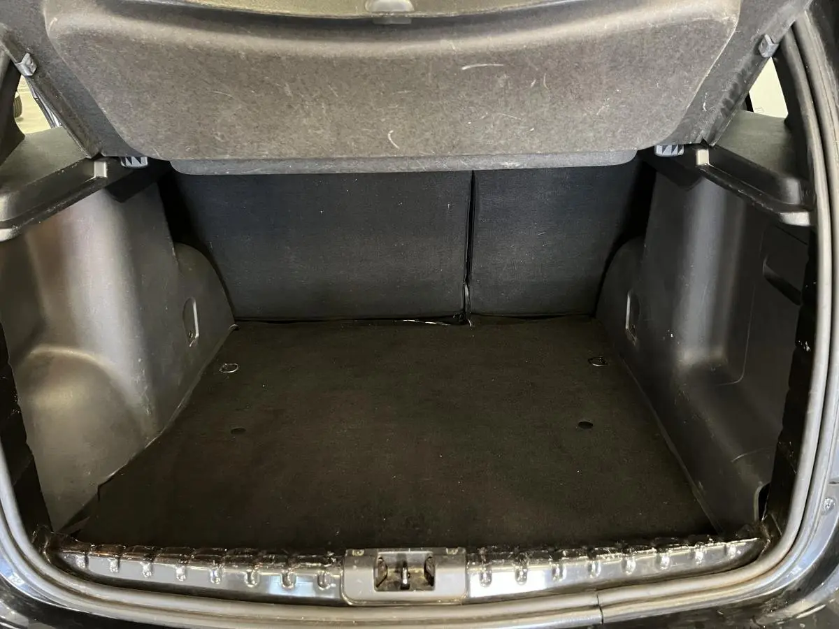 Coffre ouvert du Dacia Duster noir 2016, vue intérieure arrière montrant l'espace de chargement vide.