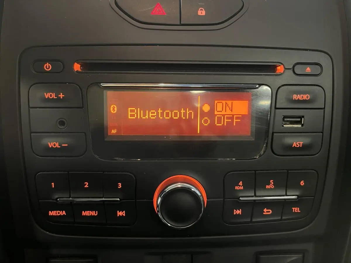 Console centrale du Dacia Duster noir 2016 avec écran radio affichant Bluetooth activé en lumière orange