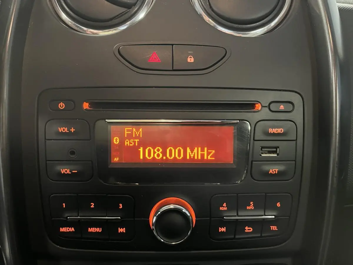Gros plan sur la radio CD MP3 avec commandes au volant du tableau de bord noir du Dacia Duster Lauréate 2016.