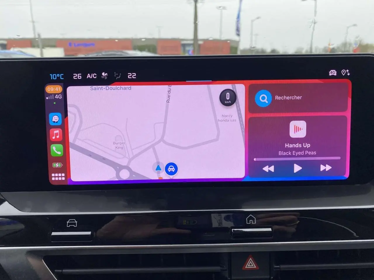Écran tactile central de la Citroën C4 X rouge Elixir affichant la navigation et la musique en extérieur.