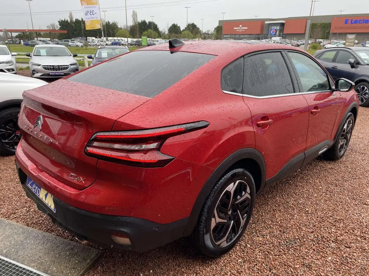 Vue 3/4 arrière droite d'une Citroën C4 X rouge Elixir avec toit ouvrant et jantes alliage 18 pouces.