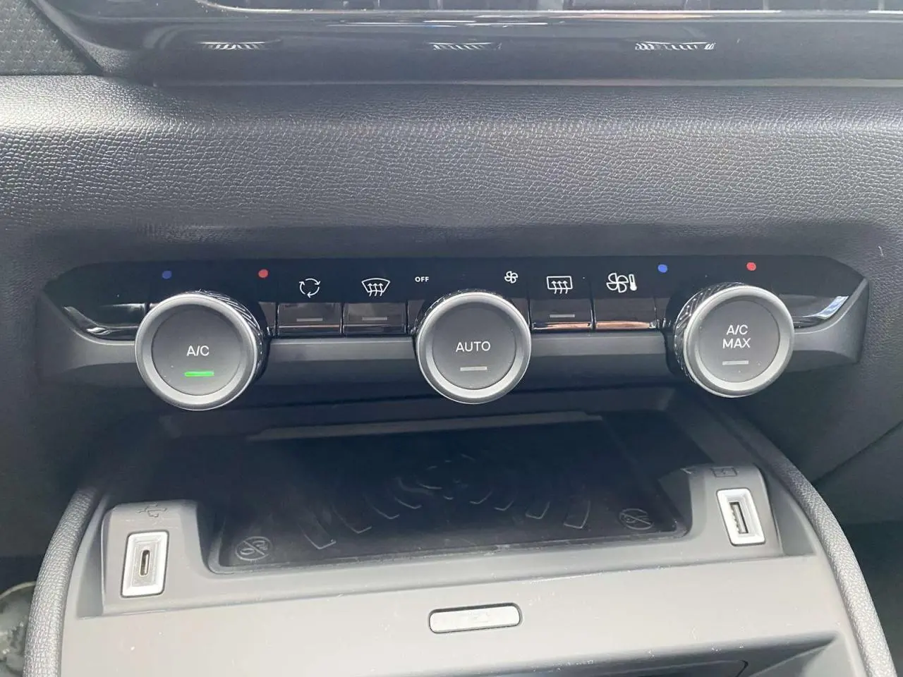 Gros plan sur les commandes de climatisation automatique et recharge sans fil du Citroën C4 X Rouge Elixir 2022.