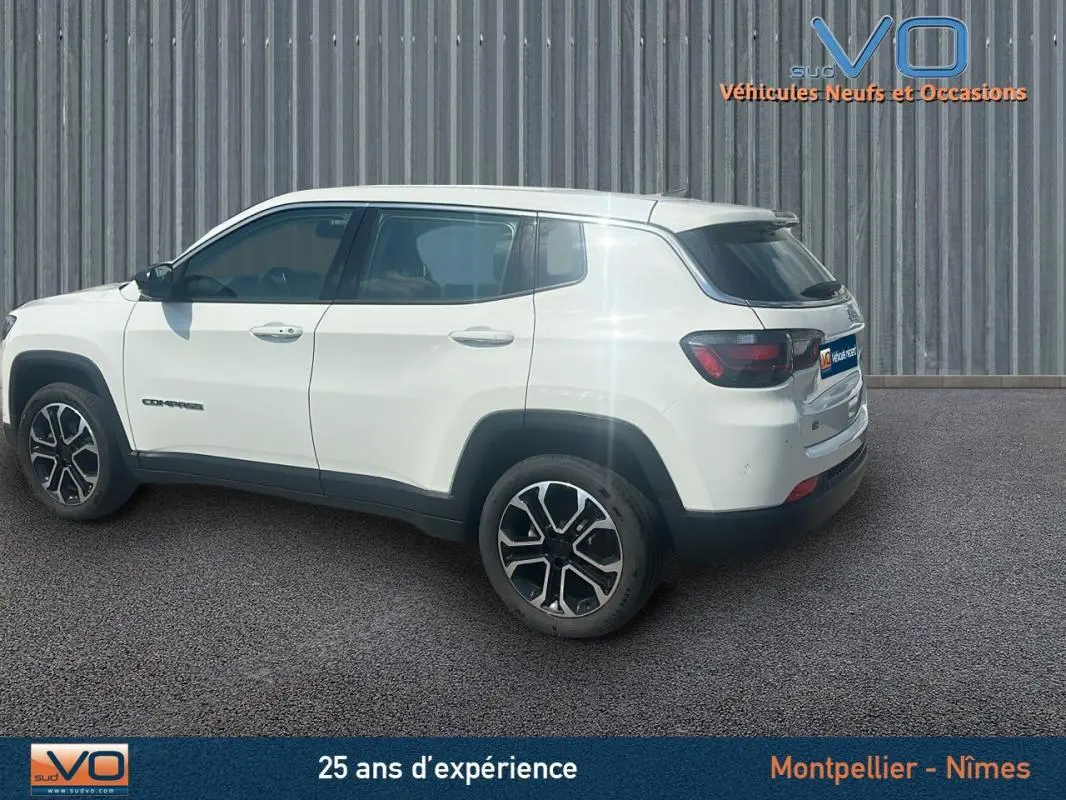 Jeep Compass blanc en vue profil côté gauche, jantes 17 pouces et roue de secours visible à l'arrière.