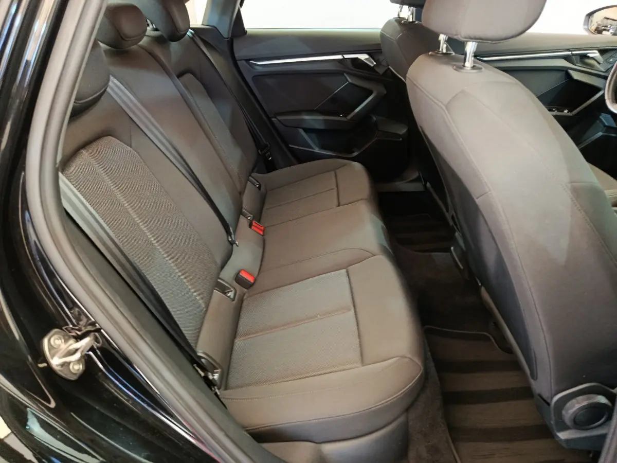 Vue intérieure côté gauche de la banquette arrière noire de l'Audi A3 30 TFSI MHEV Business Line 2022.