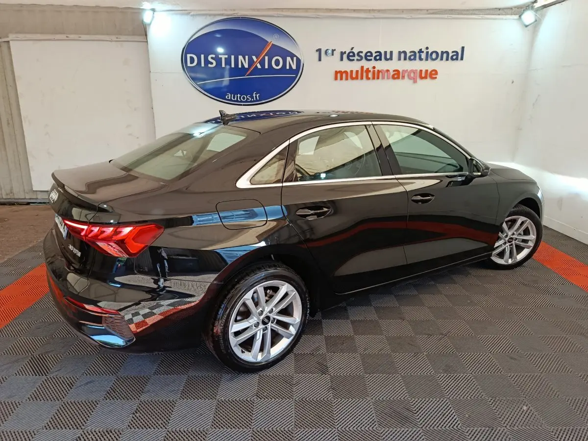 Audi A3 noire vue de trois quarts arrière droit, mettant en valeur ses feux LED et jantes alliage modernes.