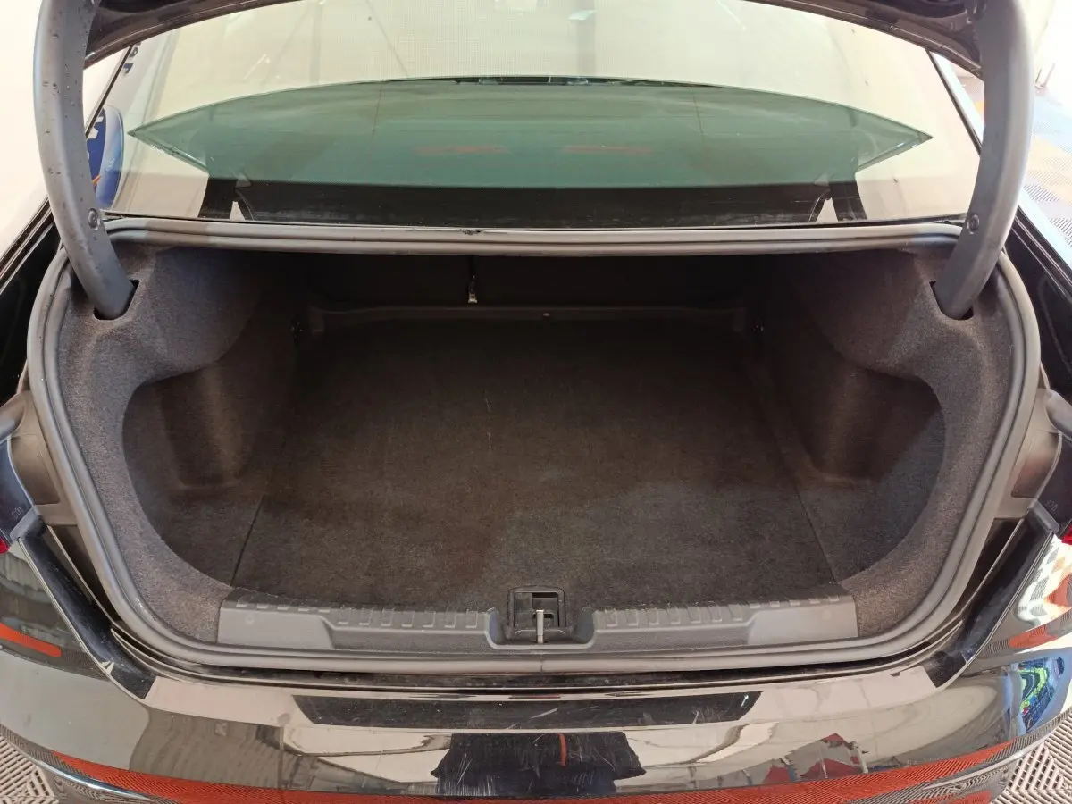 Coffre ouvert vu de l'arrière d'une Audi A3 noire 2022, montrant un espace de chargement vide et propre.