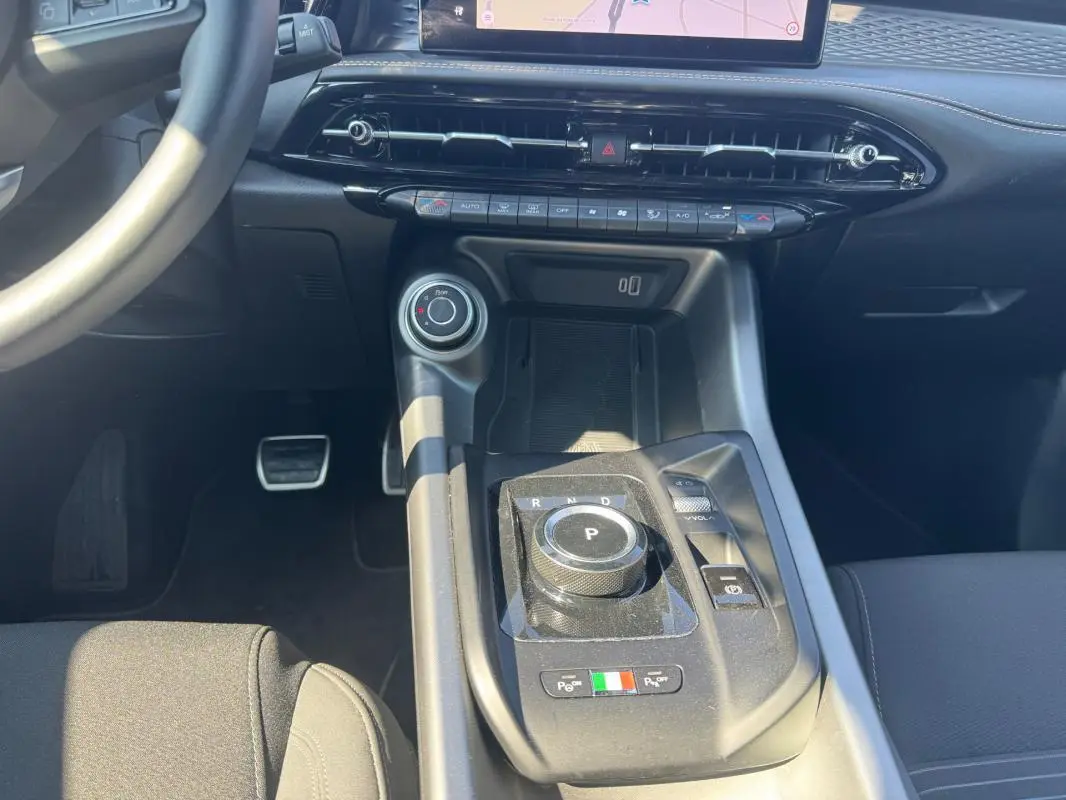 Gros plan sur la console centrale noire de l'Alfa Romeo Tonale 2025 avec molette de boîte auto et détails italiens.