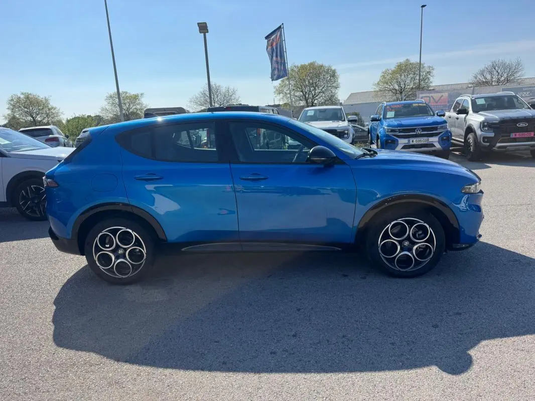 Vue de profil côté gauche d'un Alfa Romeo Tonale 2025 bleu foncé avec jantes distinctives à cinq cercles.