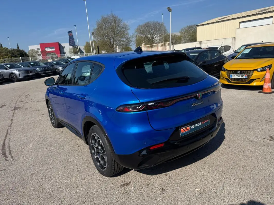Vue 3/4 arrière droite de l'Alfa Romeo Tonale 2025 bleu foncé avec feux arrière fins et jantes distinctives.