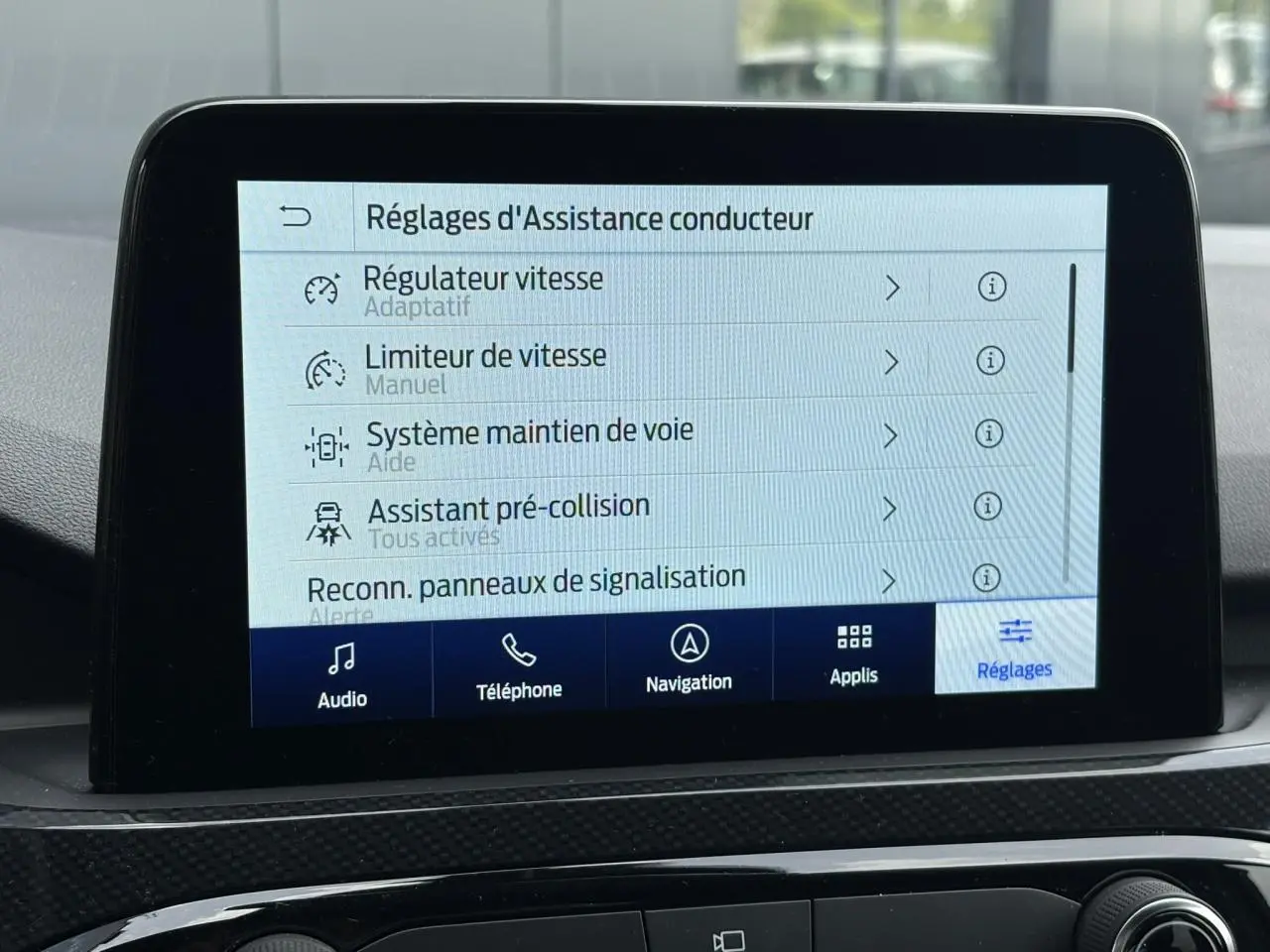 Écran tactile 8 pouces du Ford Kuga 2023 affichant les réglages d’assistance conducteur en intérieur noir.
