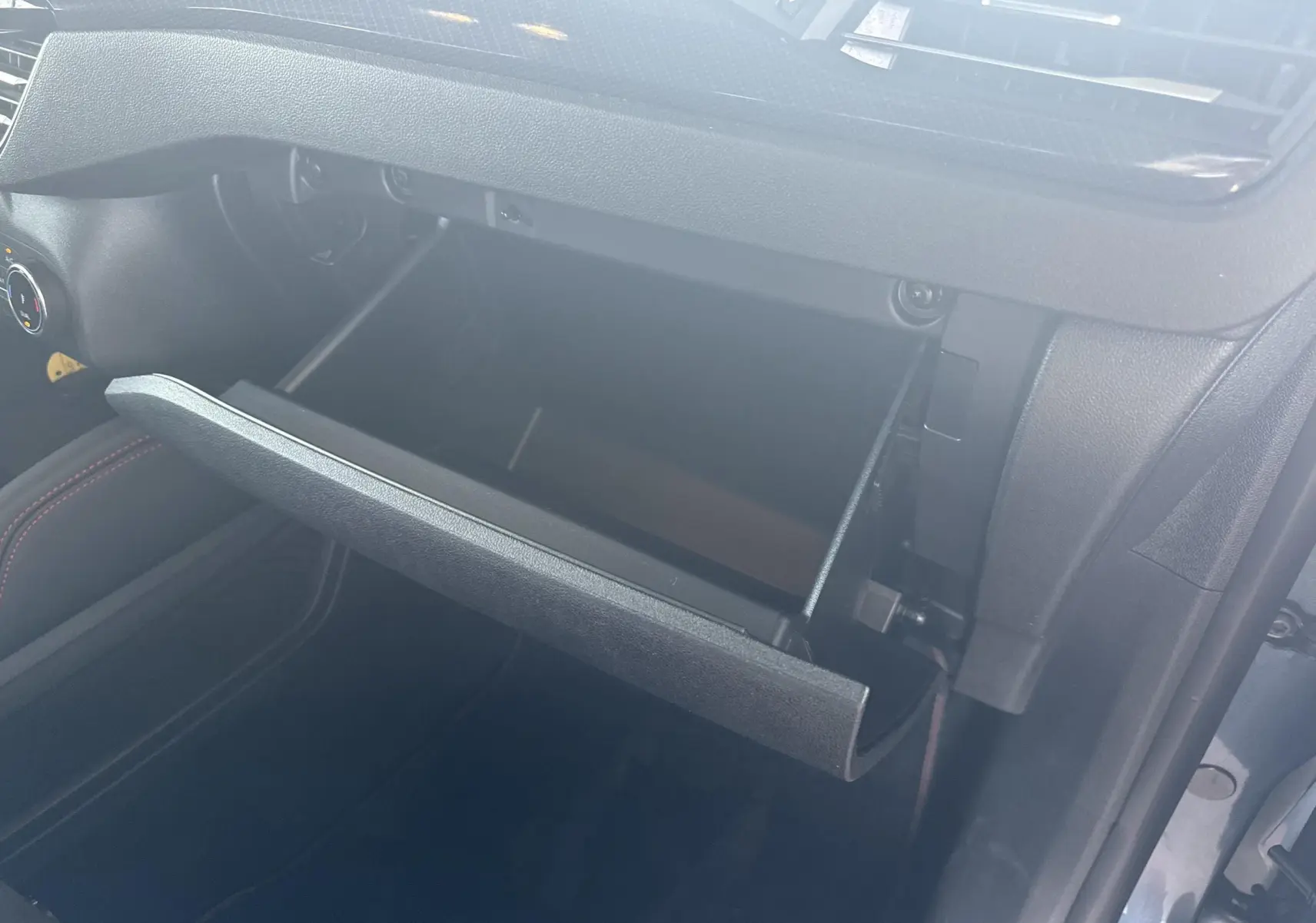 Gant de rangement ouvert côté passager dans l'habitacle du Ford Kuga Bleu Azur 2023, finition ST-Line X.