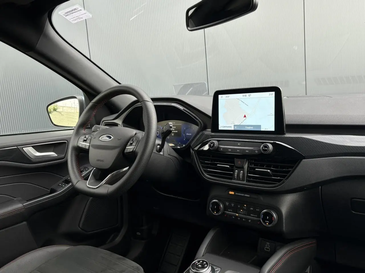 Vue intérieure côté conducteur du Ford Kuga 2023 avec volant ST-Line, écran tactile 8 pouces et finition noire élégante.