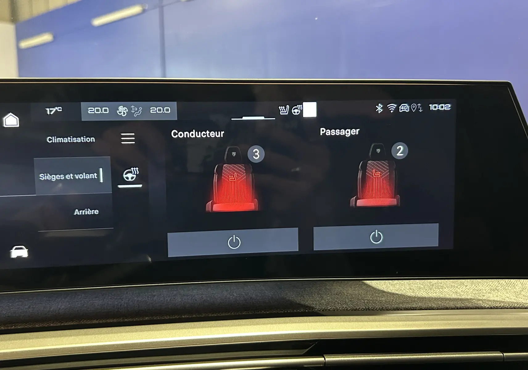 Écran tactile intérieur du Peugeot 5008 Hybrid 2025 montrant le réglage chauffant des sièges conducteur et passager.