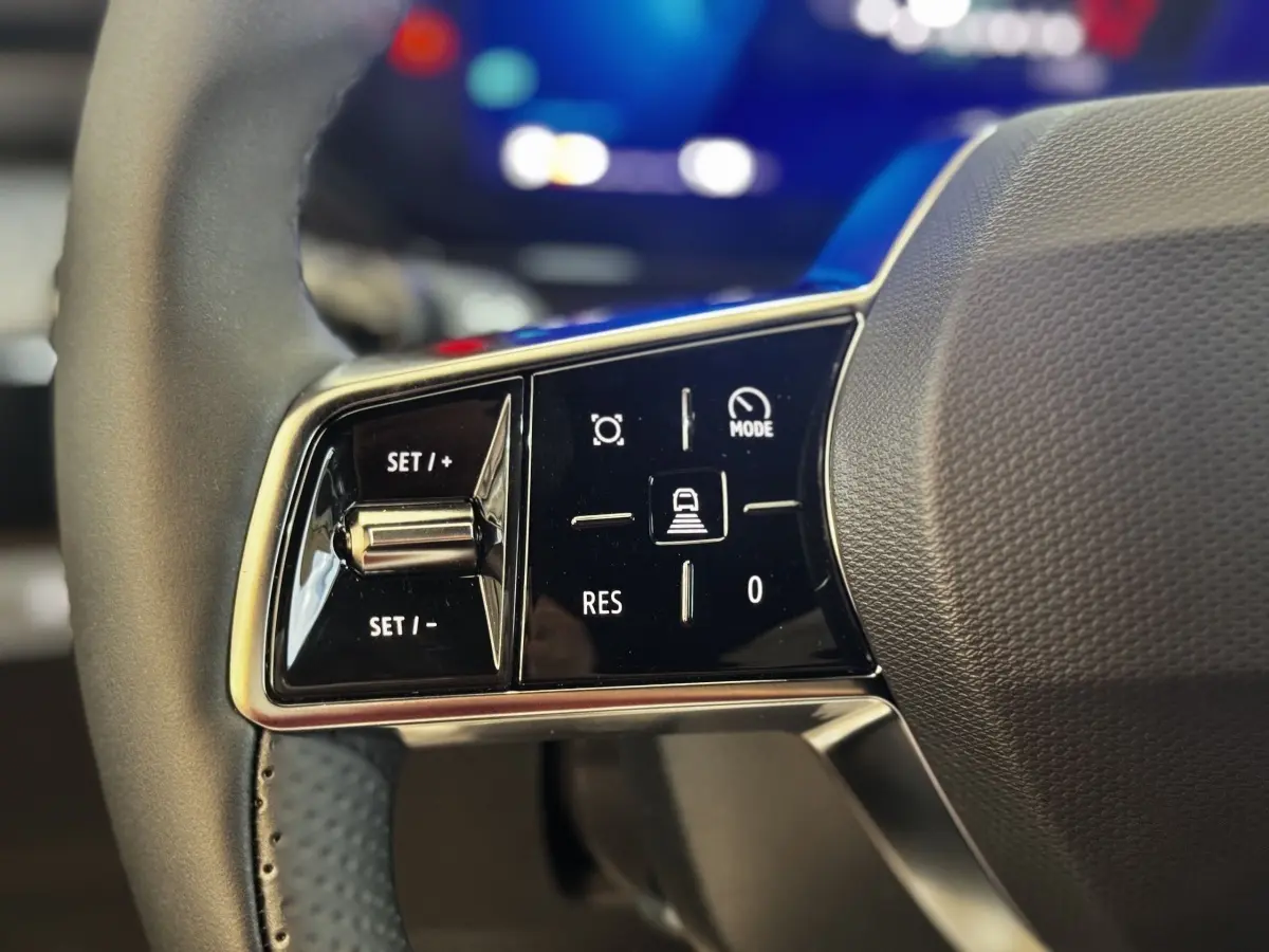Gros plan sur les commandes du volant à gauche de la Renault Clio Techno TCe 115 gris clair, boutons de régulateur de vitesse.