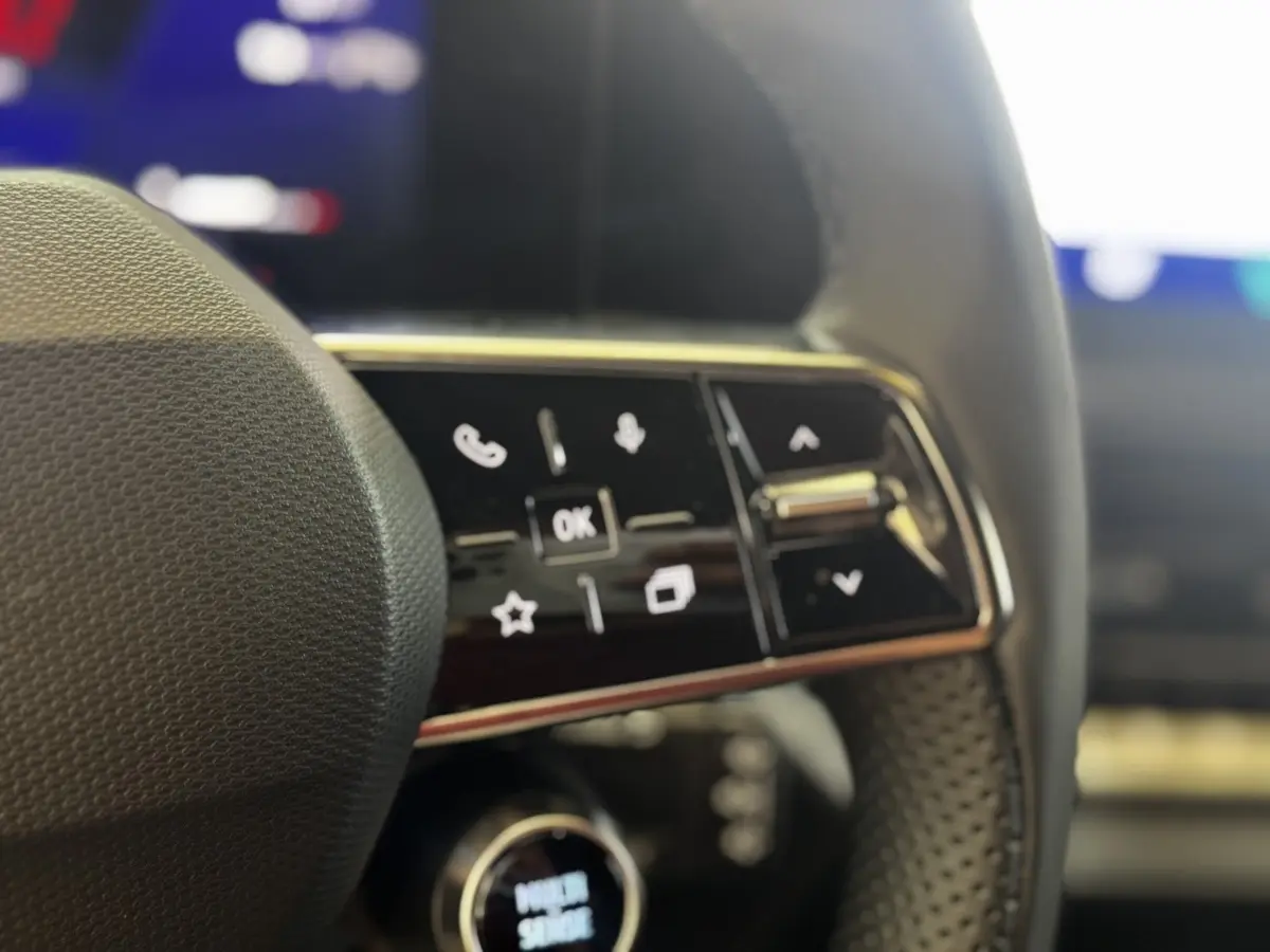 Gros plan sur les commandes multifonctions noires du volant de la Renault Clio gris clair, version techno TCe 115 ch.