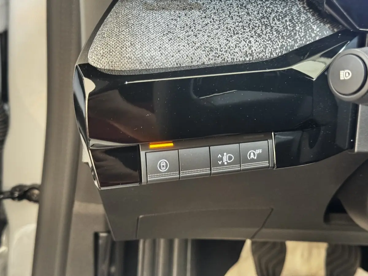 Gros plan sur les commandes noires du tableau de bord côté gauche de la Renault Clio Techno gris clair 2026.