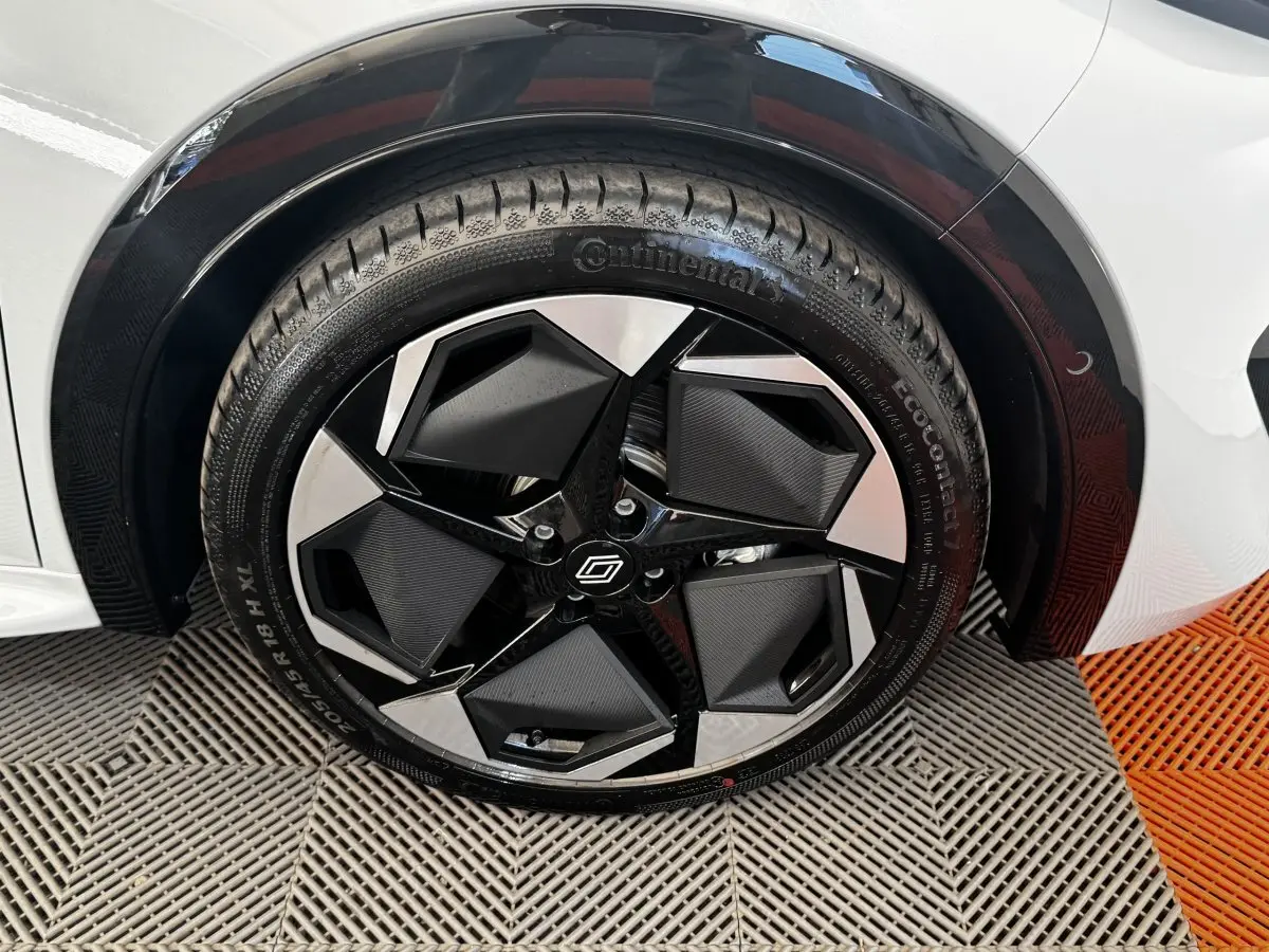 Gros plan sur la roue avant droite gris clair de la Renault Clio 2026 avec jante noire et argentée au design géométrique.