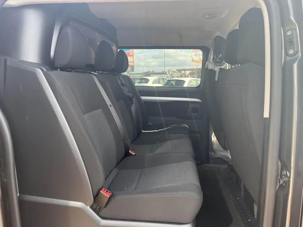 Banquette arrière noire vue de côté gauche dans le Peugeot Expert Fourgon gris platinium 2023 cabine approfondie.