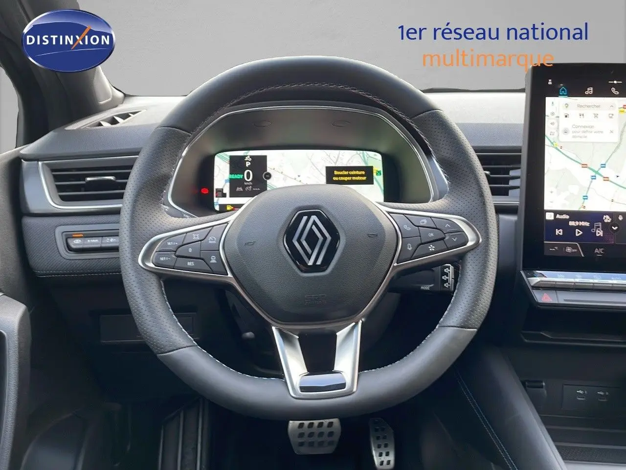 Vue centrée sur le volant noir perforé du Renault Captur E-Tech 2025 avec tableau de bord numérique et écran tactile.