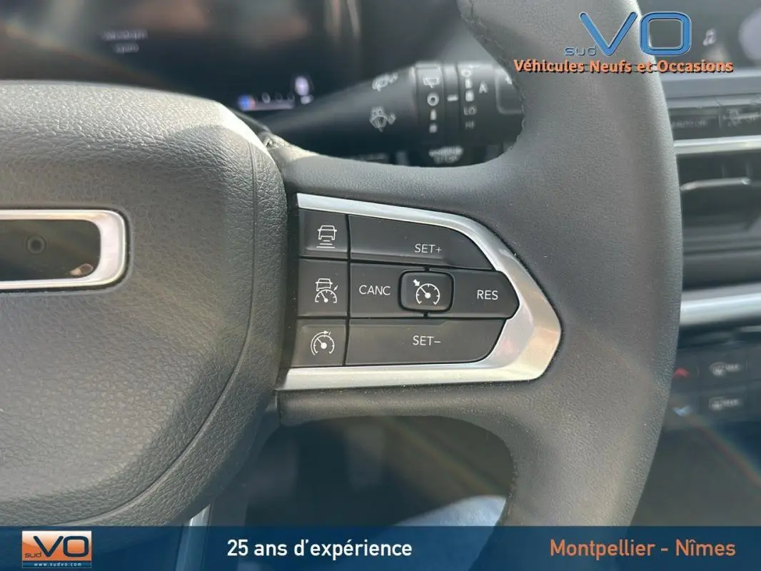 Gros plan sur les commandes du régulateur de vitesse au volant d’un Jeep Compass gris 2024 e-Hybrid Altitude