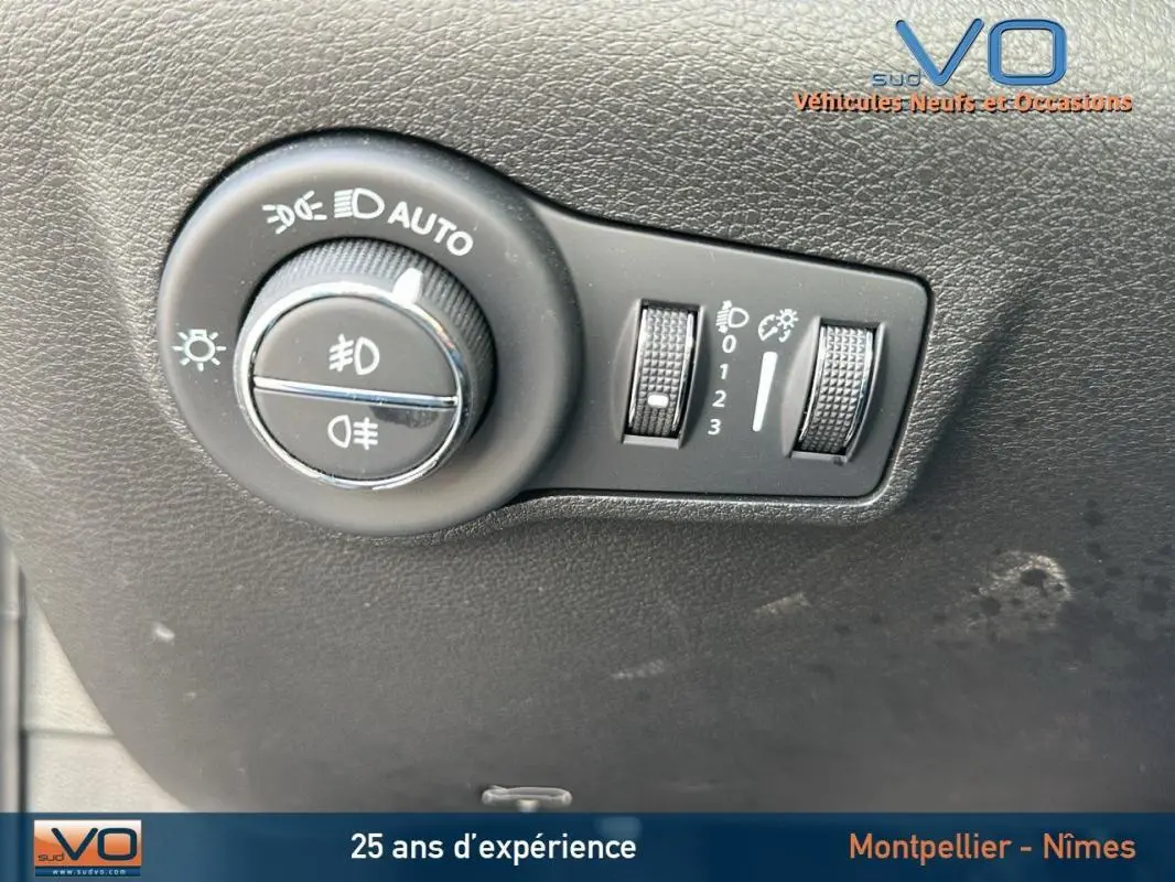 Gros plan sur les commandes d'éclairage et réglages de phares du Jeep Compass 2024 gris, intérieur côté conducteur.