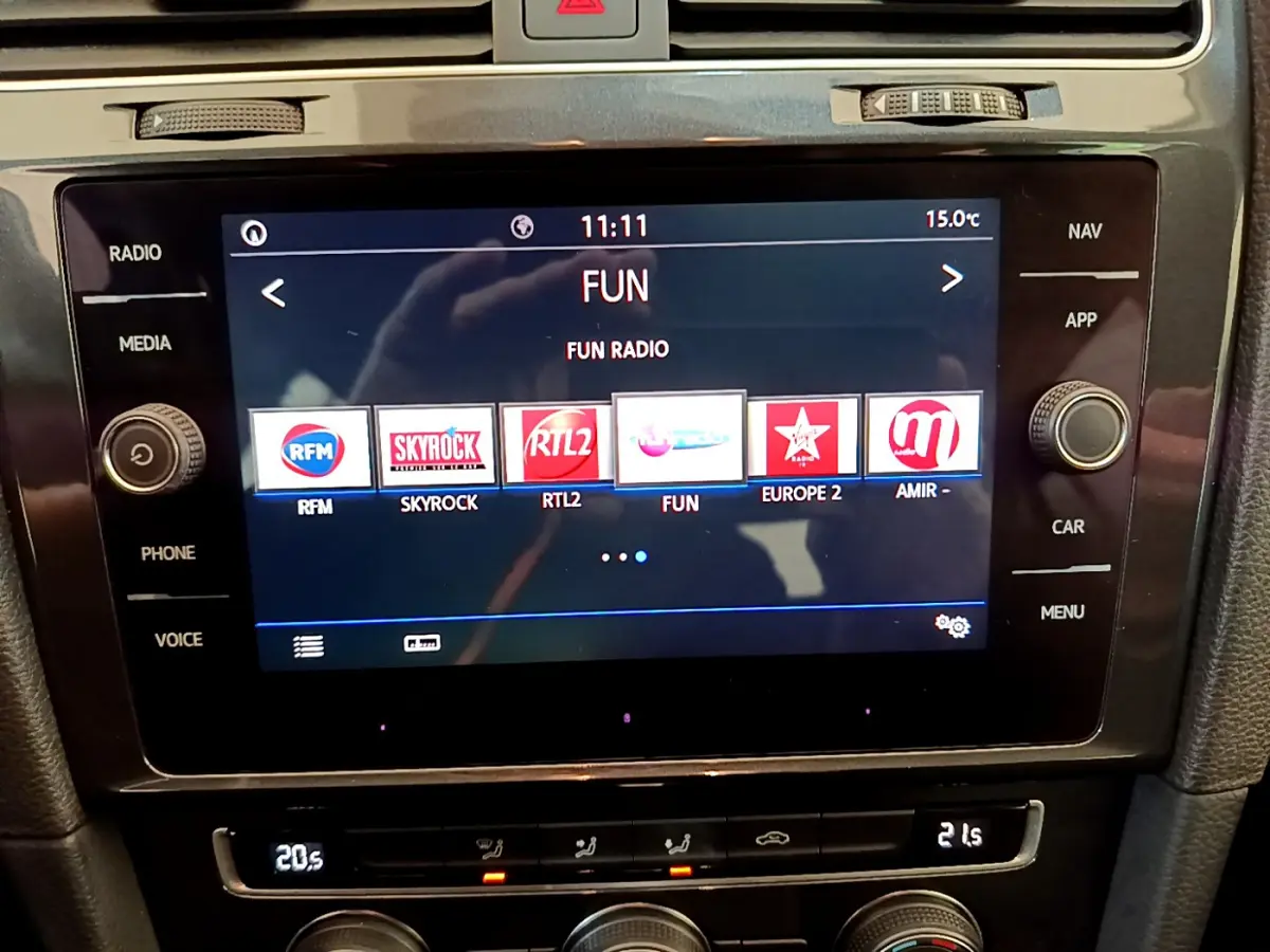 Écran tactile central de la Volkswagen Golf 2019 affichant les stations radio, entouré de commandes noires.