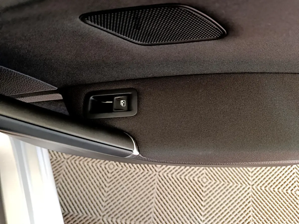 Détail du plafond intérieur noir avec commande d'ouverture de toit ouvrant de la Volkswagen Golf gris clair 2019.