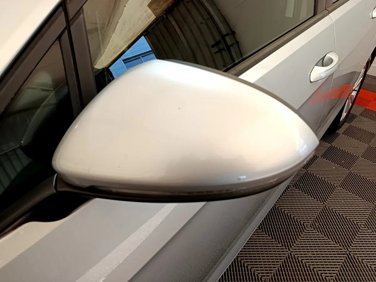 Rétroviseur côté gauche gris clair de Volkswagen Golf 1.6 TDI 2019 avec portière et poignée visibles en arrière-plan.