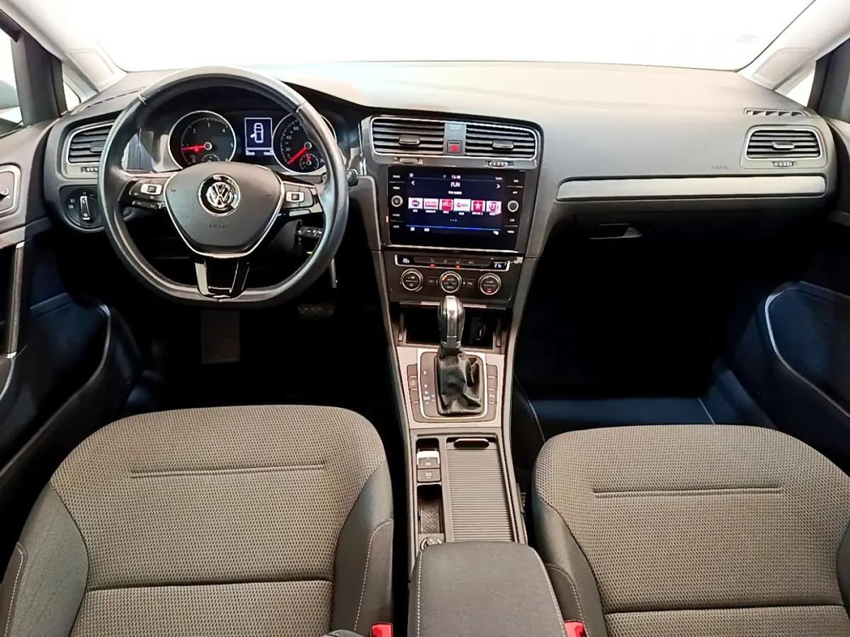 Vue intérieure avant de la Volkswagen Golf 1.6 TDI 2019, tableau de bord noir avec écran tactile et volant multifonctions cuir.