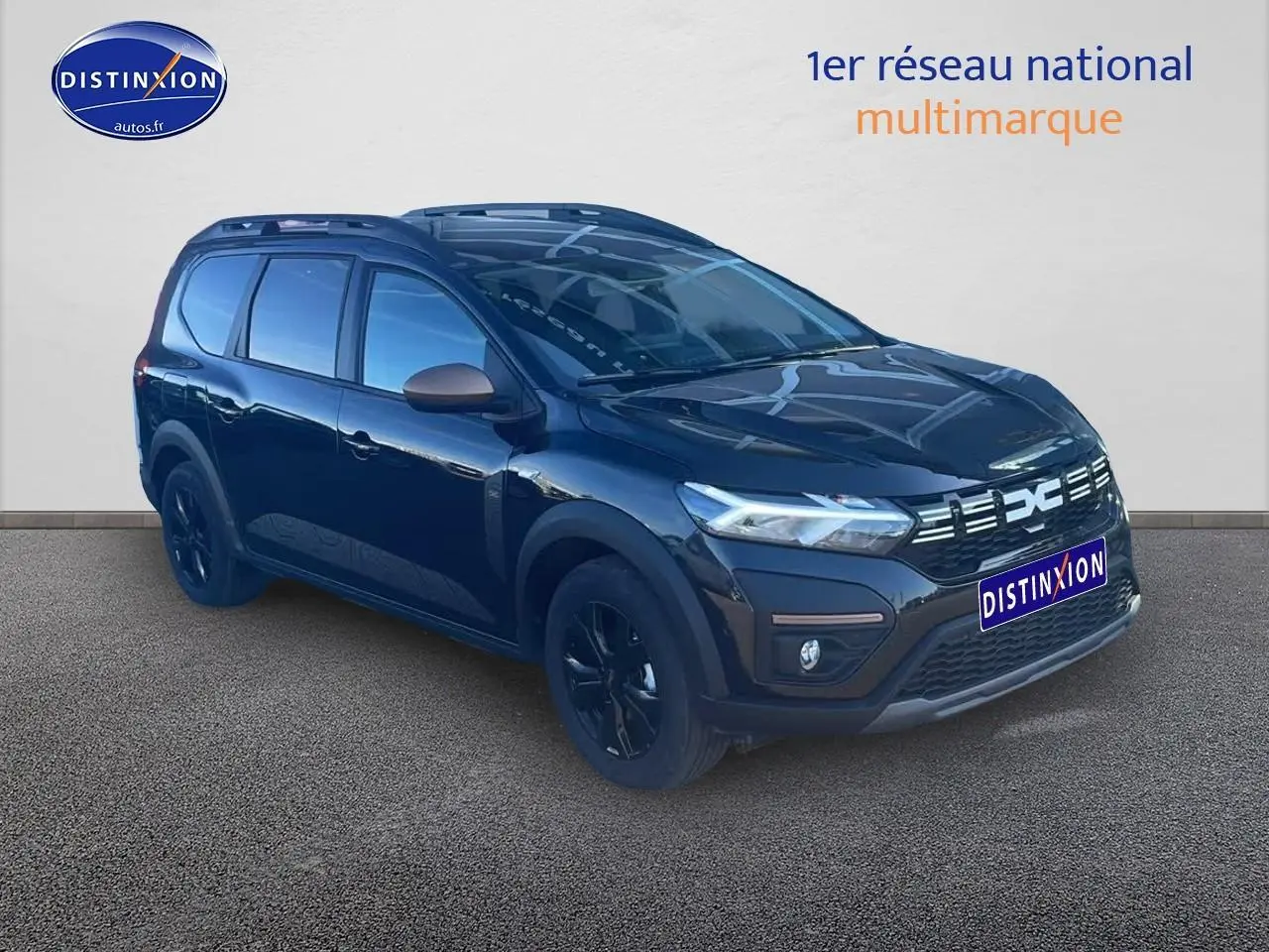 Dacia Jogger 1.6 hybrid noir nacré en 3/4 avant droit avec barres de toit et jantes noires.
