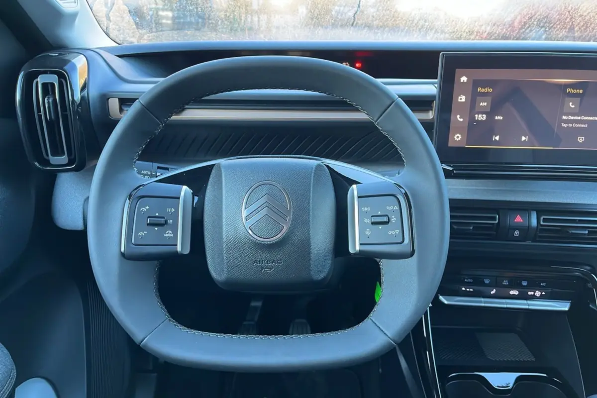 Vue rapprochée du volant cuir multifonctions et du tableau de bord numérique du Citroën C3 Aircross noir perla nera.