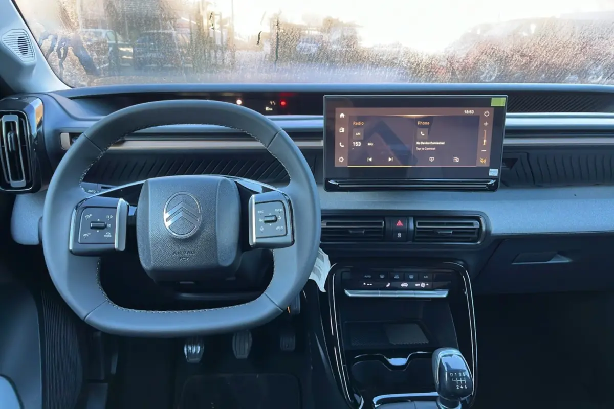 Vue intérieure centrée sur le volant cuir multifonctions et l'écran tactile 10,25 pouces du Citroën C3 Aircross 2025.