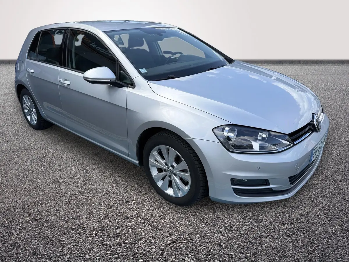 Volkswagen Golf gris clair vue 3/4 avant droit, avec phares halogènes et rétroviseurs électriques rabattables.