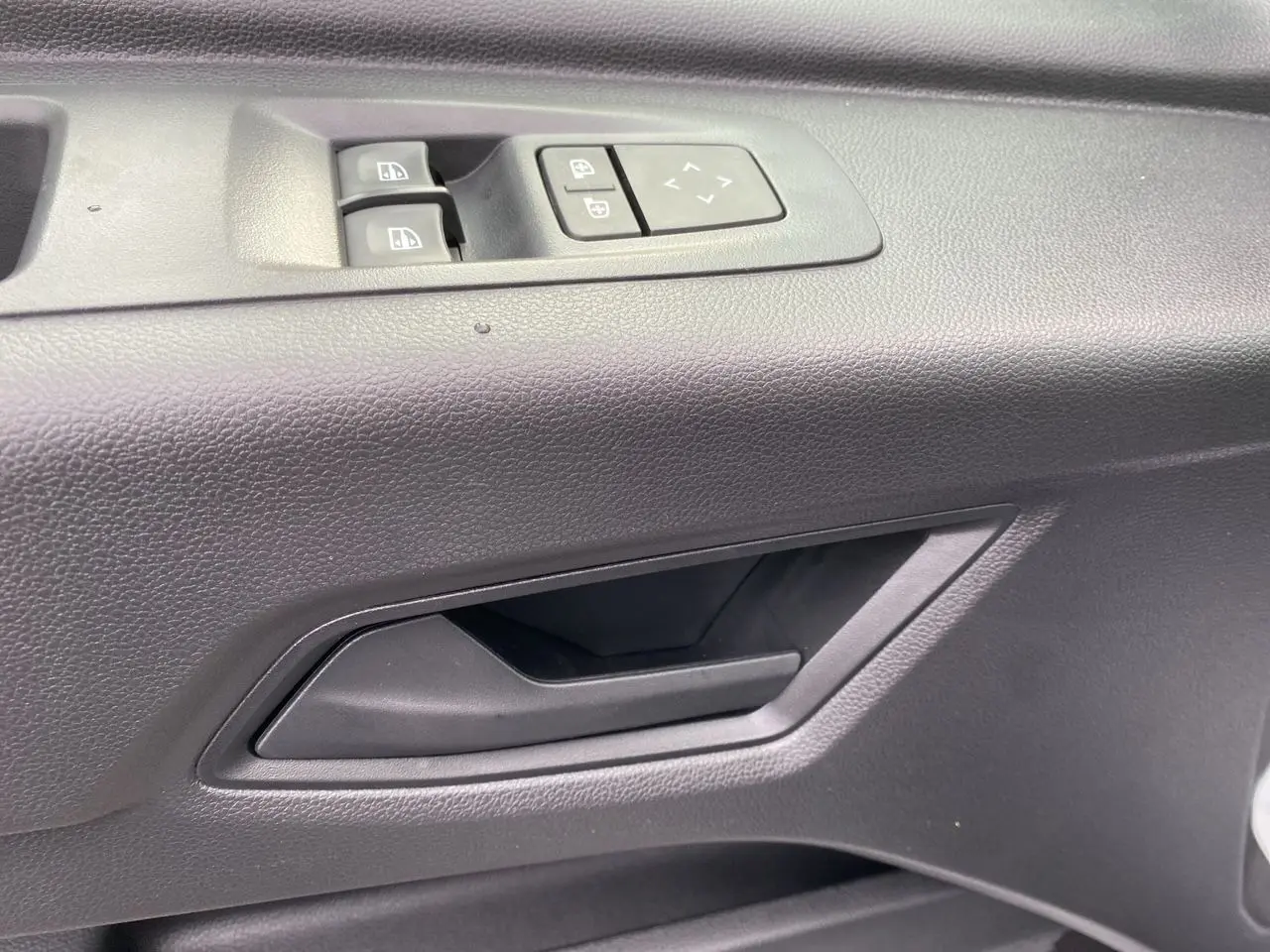 Poignée intérieure et commandes des vitres côté conducteur du Renault Master IV FG 3T5 blanc, vue rapprochée.