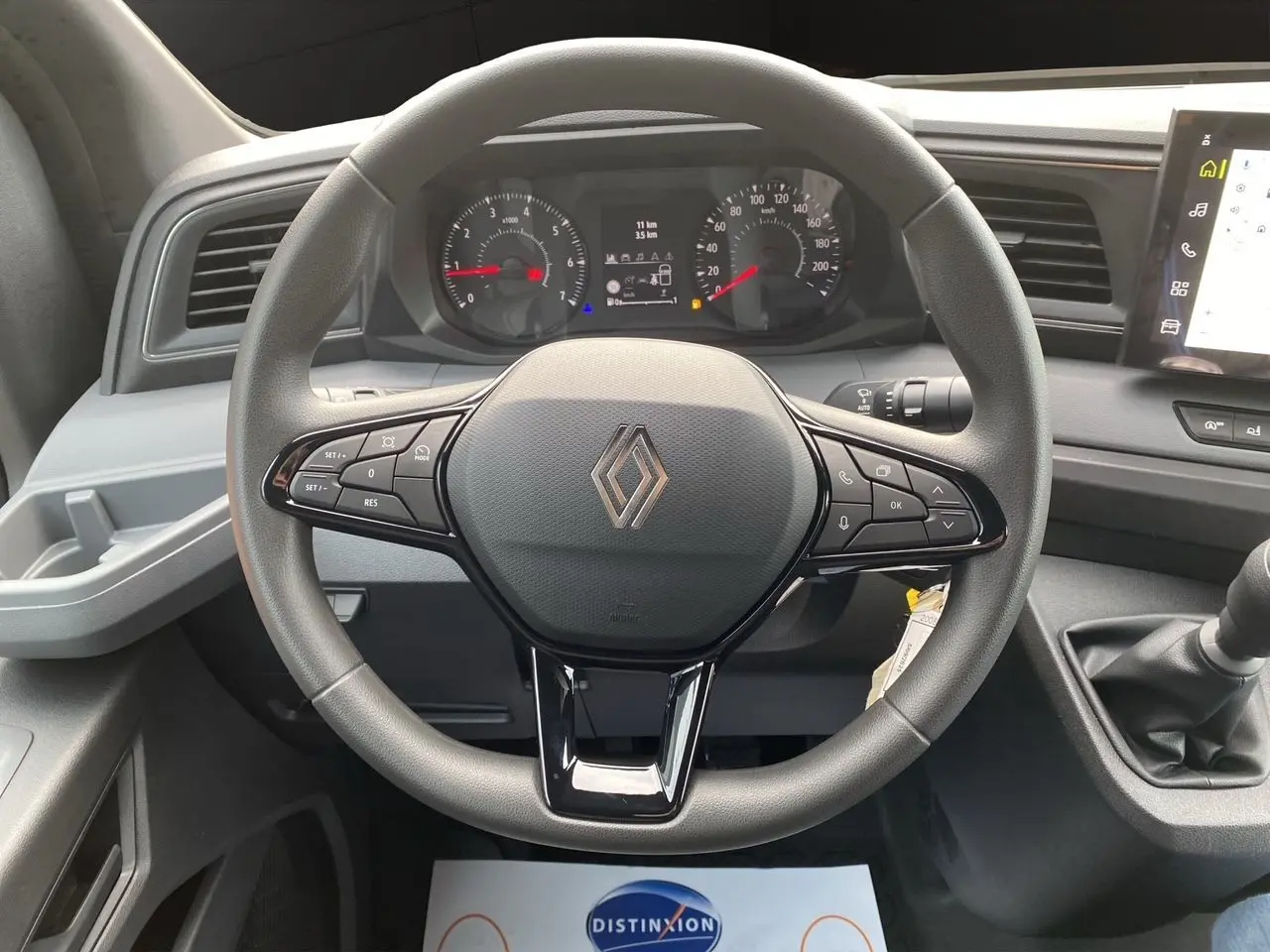 Vue rapprochée du volant et du tableau de bord du Renault Master 2025 avec commandes intégrées et levier de vitesses manuel.