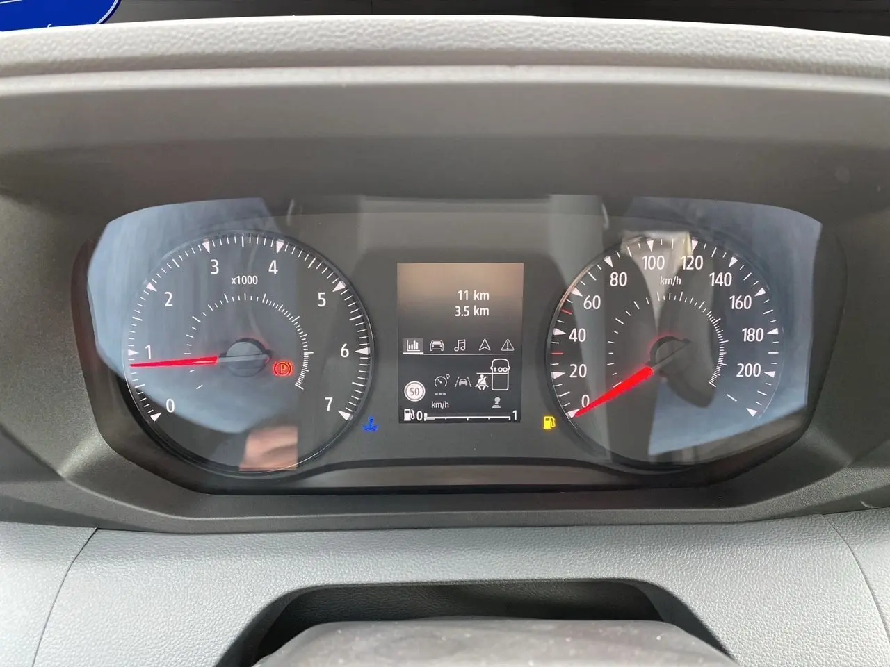 Gros plan sur le combiné d'instrumentation du Renault Master blanc, affichant compte-tours, vitesse et écran central digital.