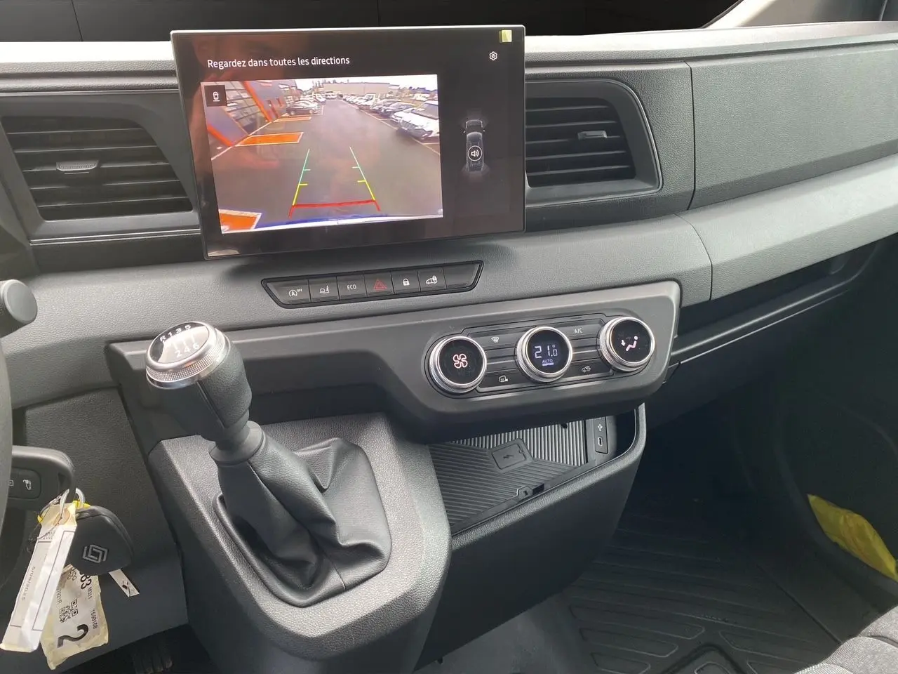 Vue intérieure du tableau de bord du Renault Master 2025, avec levier de vitesse manuel et écran de caméra de recul allumé.
