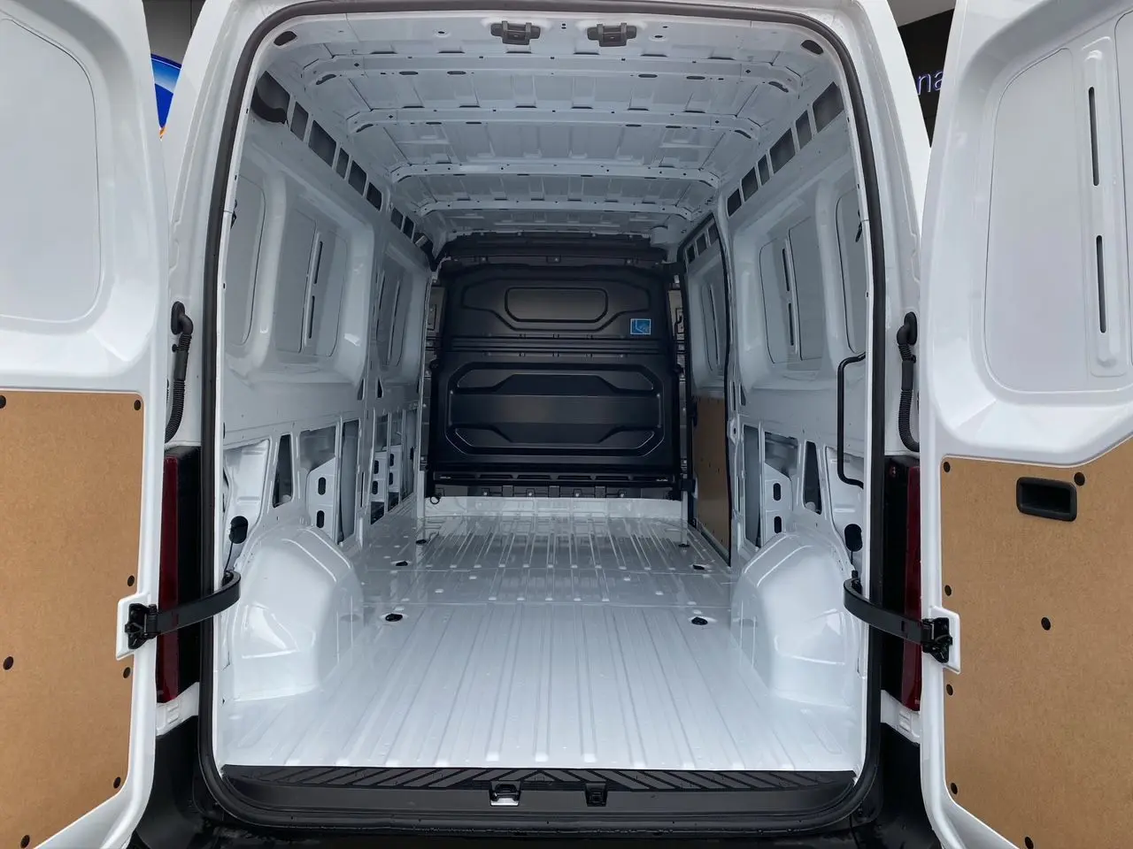 Vue arrière du Renault Master blanc 2025 avec portes arrière ouvertes montrant l'espace de chargement vide et tôlé.