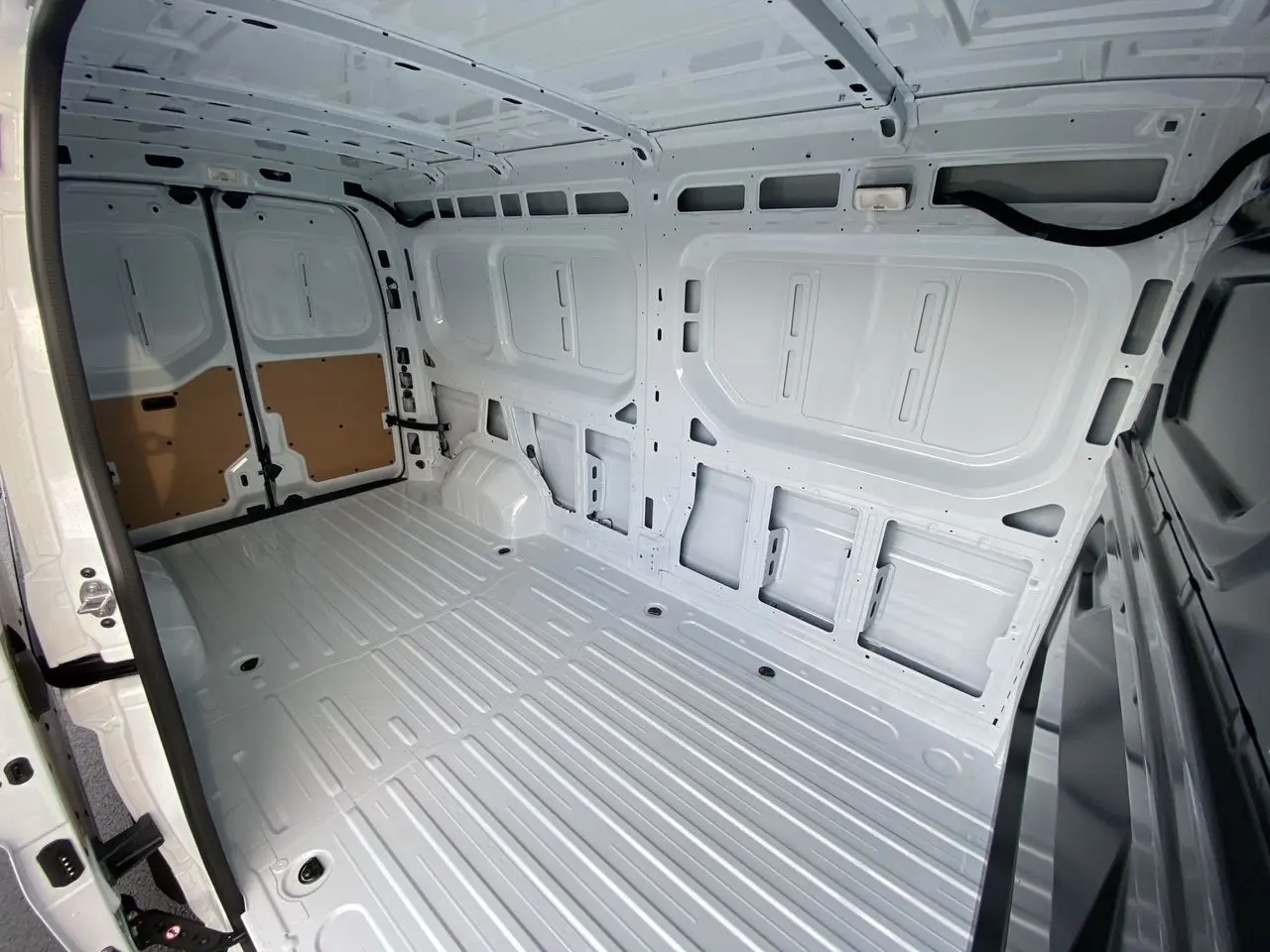 Vue intérieure arrière du Renault Master blanc 2025, montrant l’espace de chargement tôlé et le plancher métallique.