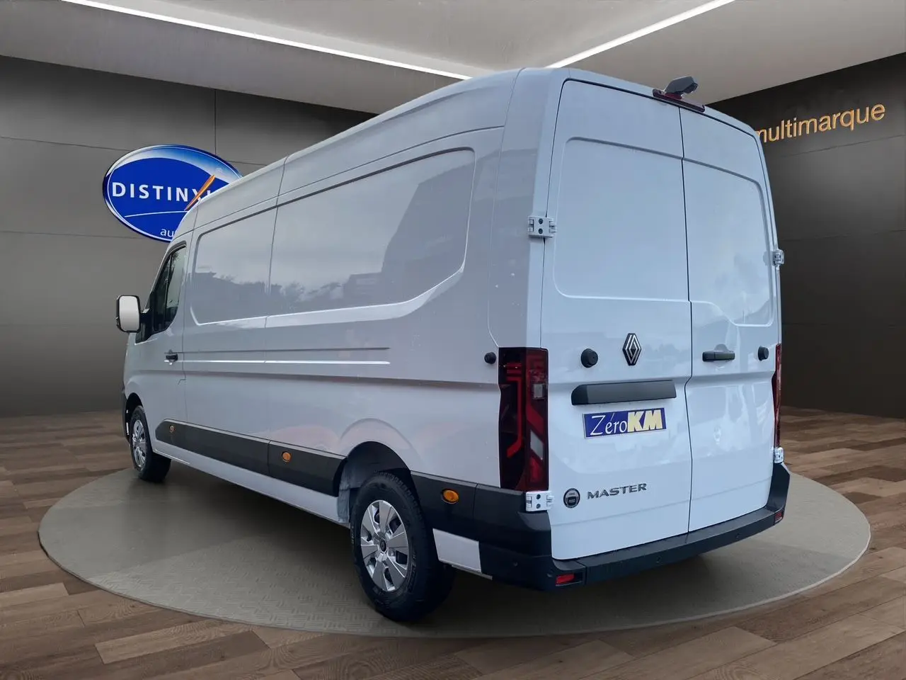 Renault Master blanc vu 3/4 arrière droit, portes arrière tôlées ouvertes à 270°, enjoliveurs noirs visibles.