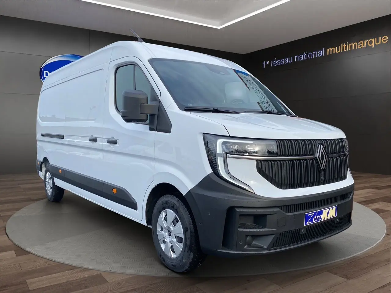 Vue 3/4 avant d’un Renault Master blanc avec calandre noire et enjoliveurs argentés, stationné en intérieur.