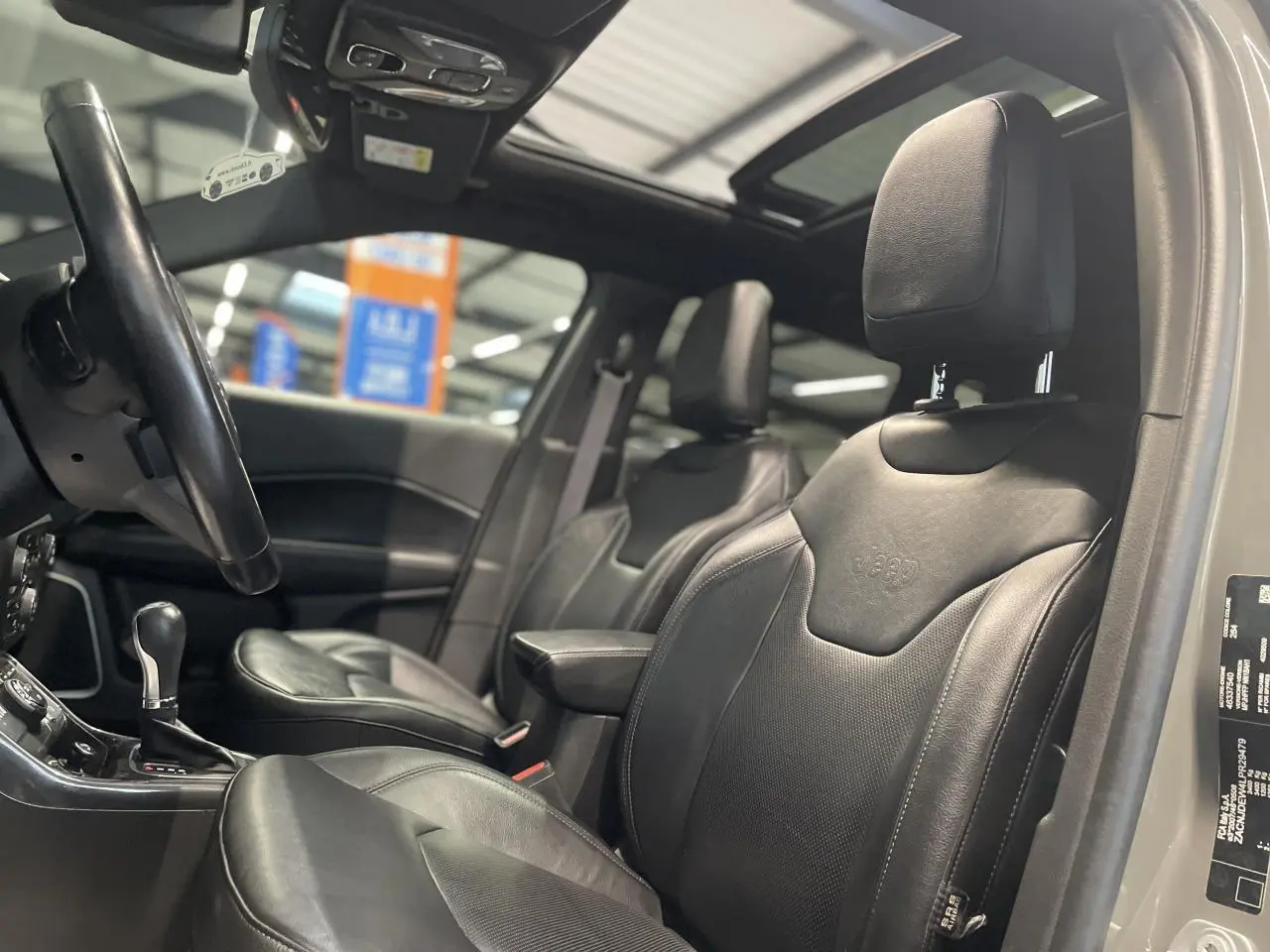 Intérieur Jeep Compass 2021, vue côté gauche sur sièges cuir noirs et toit ouvrant panoramique CommandView.