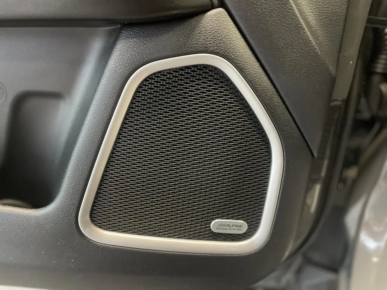 Gros plan sur l'enceinte Alpine intégrée à la porte intérieure d'un Jeep Compass gris foncé Trailhawk 2021.