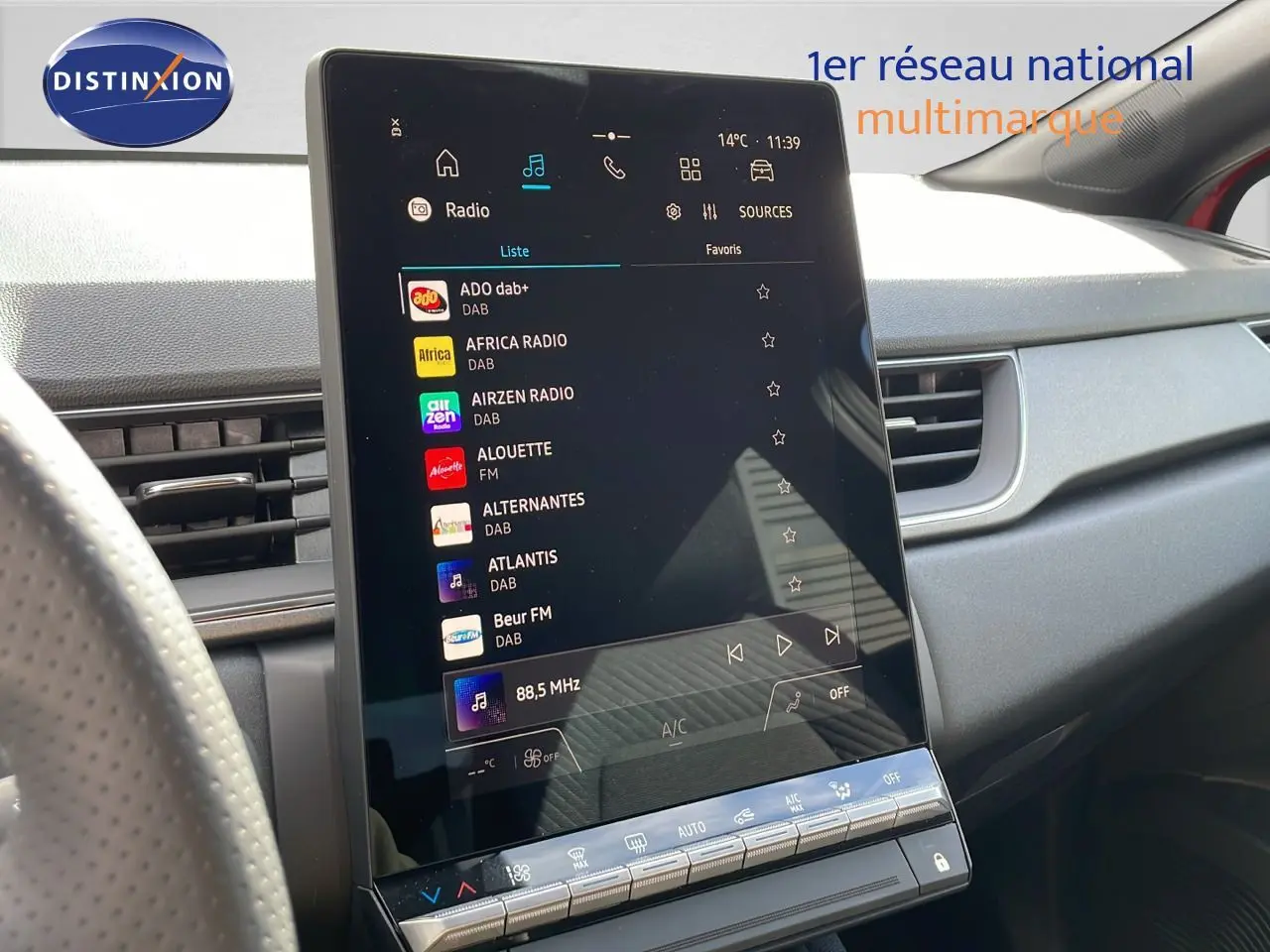 Écran tactile central affichant les stations radio dans l’habitacle du Renault Captur E-Tech hybride rouge toit noir.
