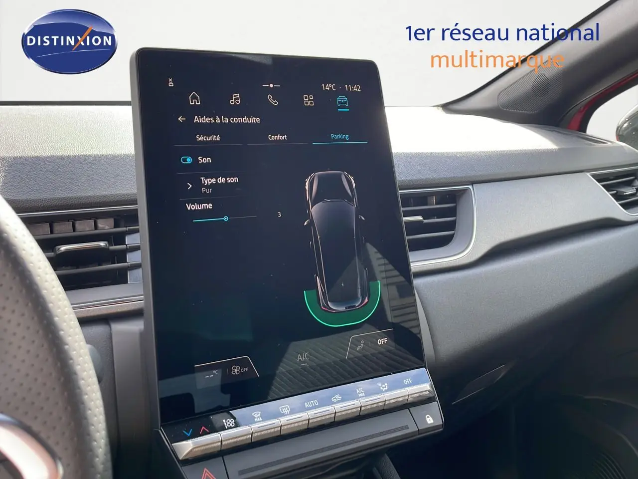 Écran tactile central du tableau de bord du Renault Captur rouge passion, affichant les aides à la conduite.