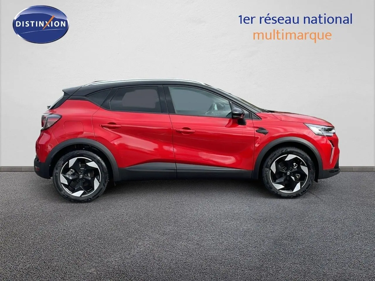 Profil côté gauche du Renault Captur E-Tech hybride 2025 rouge passion avec toit noir et jantes bicolores.
