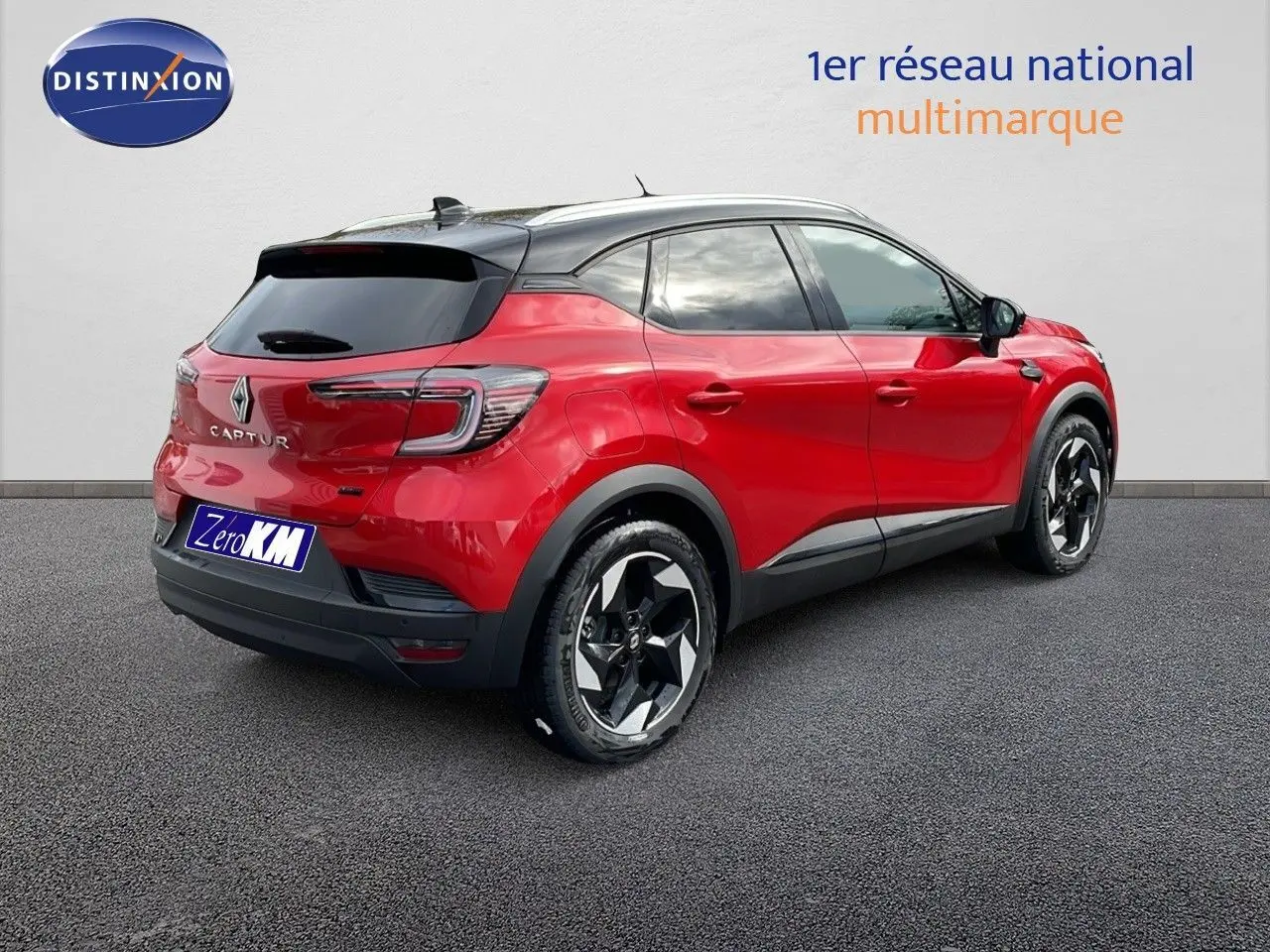 Vue 3/4 arrière droite d'un Renault Captur 2025 rouge passion avec toit noir et jantes bicolores distinctives.